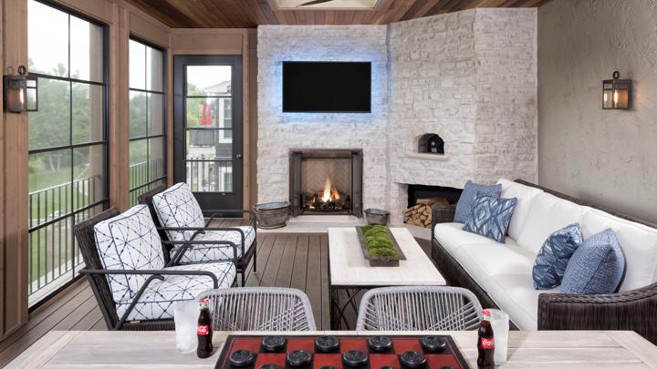 Covered four-season patio with classic wood fireplace in white brick hearth.