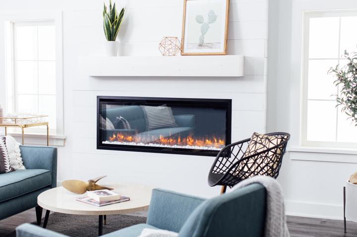 Finished installation of modern electric fireplace in shiplapped bump-out wall in Transitional living room.